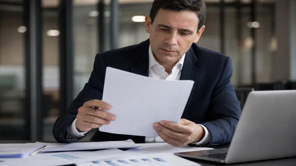 Como o impacto de mudanças tributárias afeta pequenas empresas 2 Especialista revisando documentos de falhas no cumprimento das novas leis relacionados à impacto de mudanças tributárias.